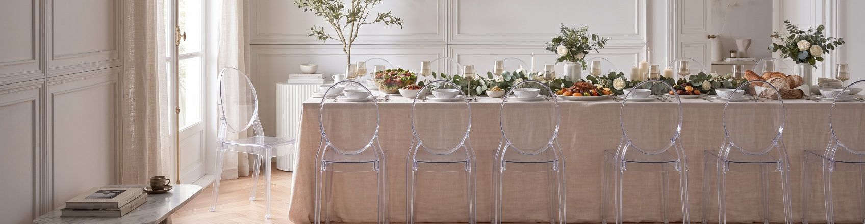 elegant banquet room with transparent chairs and wide table