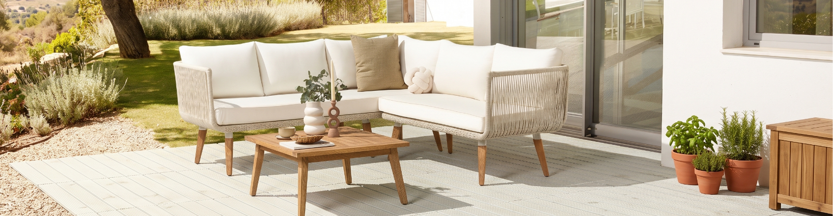modern lounge set placed in a garden outside a big house