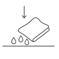 Paper towel blotting liquid drops on upholstery fabric